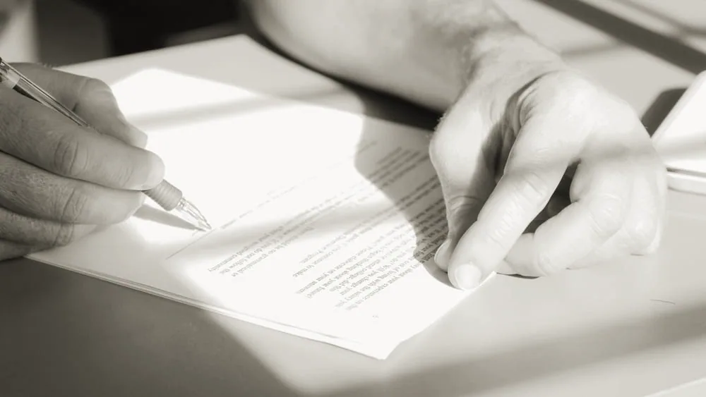A loan document being reviewed and signed at a desk